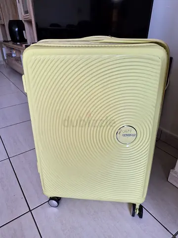 American tourister yellow suitcase