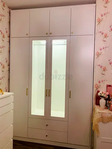 White built-in wardrobe with mirrored doors, drawers and top cabinets