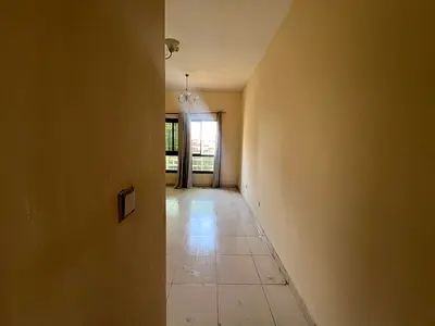 For rent in Emirates City: 2-bedroom apartment with living room, 2 bathrooms, balcony, central AC, free parking, AED 34,000 in 4 installments