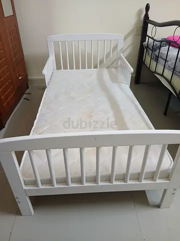 White wooden baby crib with mattress