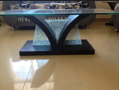 Glass-top coffee table with decorative wood and textured glass base