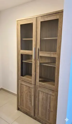 Tall wooden display cabinet with glass doors