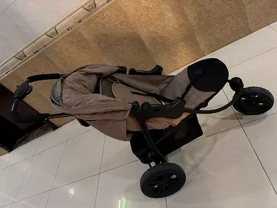 Beige 3-wheel jogging stroller in good condition
