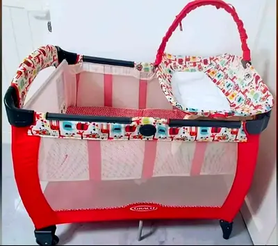 Red portable playpen/crib with bassinet and changing station