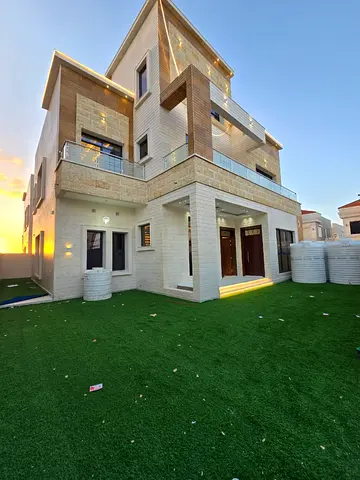 Villa for sale on a corner lot with two street frontages, including registration and ownership fees, opposite Azha Residential Complex and close to al