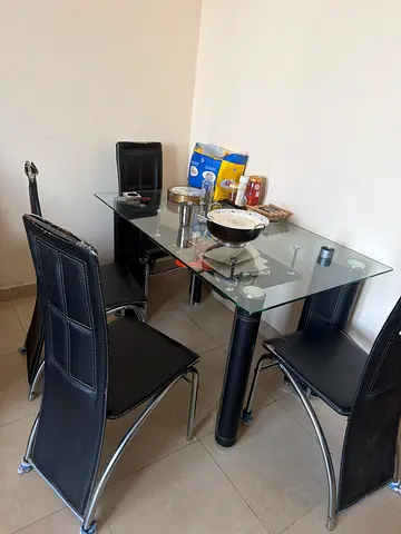 My glass-top dining set with 4 black chairs — good condition