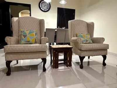 Cream patterned 2-seater loveseat with carved wooden legs