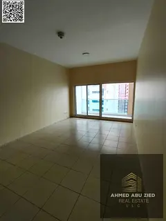 A spacious one-bedroom apartment with a living room and balcony, one of the largest in Ajman One Tow