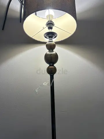 Tall floor lamp with stacked orb base and beige fabric shade