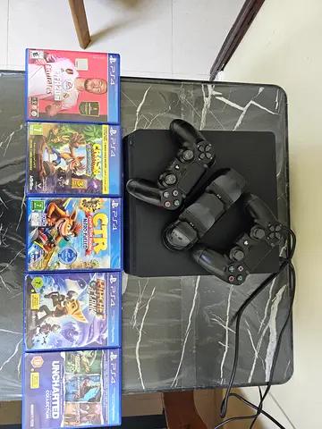 Playstation 4 slim with 2 controller, a charger, and 5 games