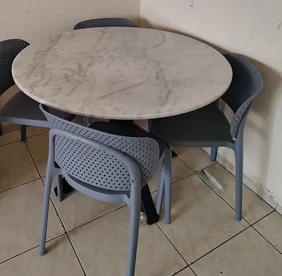 My round marble-top dining table with 4 grey chairs