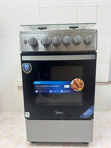 Midea freestanding gas range with oven — 4-burner hob and glass lid