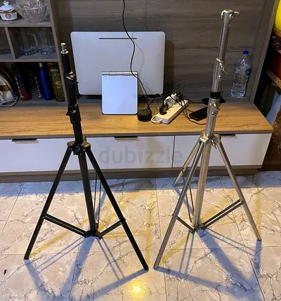 tripod/light stands — one silver aluminum, one black steel — used, good condition
