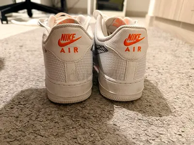 White Nike Air Force 1 sneakers with orange logo - pre-owned