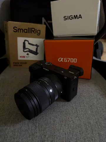 Sony Alpha 6700 with a small rig cage and a sigma 18mm to 50mm zoom lens an a 128GB lexar 2000x