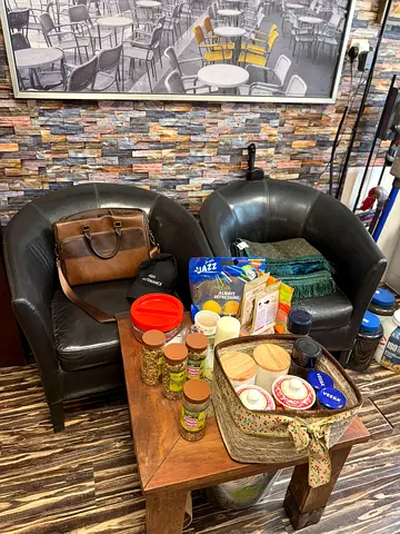Pair of black tub chairs (leather-look) with small wooden coffee table