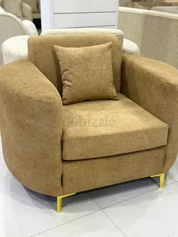 Beige fabric armchair with gold legs