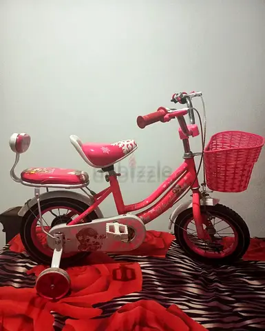 My pink kids bike with training wheels and front basket