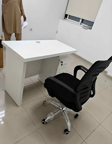 White office desk with lockable drawer and black ergonomic chair (