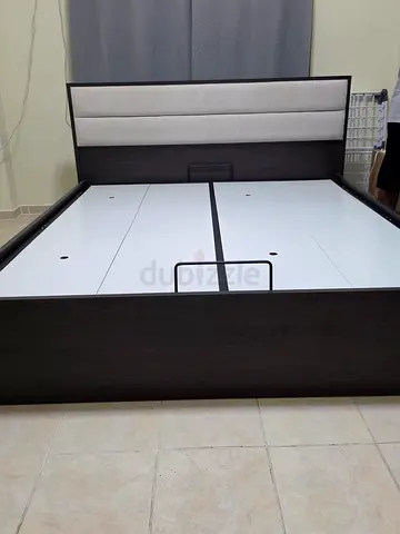Dark wood platform bed frame with padded upholstered headboard