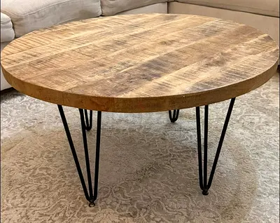 Round solid wood coffee table with black hairpin legs