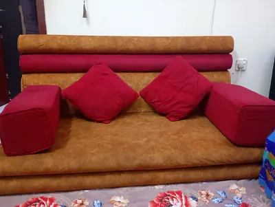 Brown faux-leather 2-seater sofa with red cushions