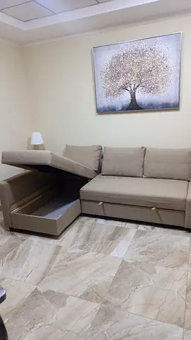 Beige L-shaped sofa bed with storage - good condition