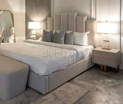 Light grey upholstered bed frame with tall padded headboard