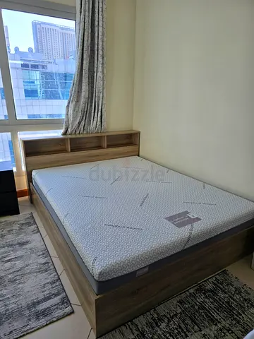 Single wooden bed frame with mattress and built-in headboard shelf