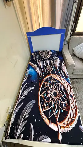 Single kids bed with blue headboard and dreamcatcher bedding