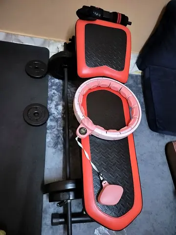 Compact workout bench with curl barbell, plates and weighted hula hoop