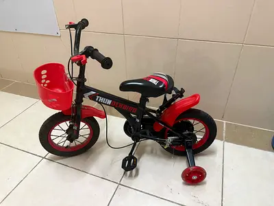 My childs red  black kids bike (12-inch) with training wheels and front basket