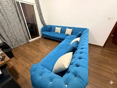 Blue velvet L-shaped tufted Chesterfield-style sectional sofa