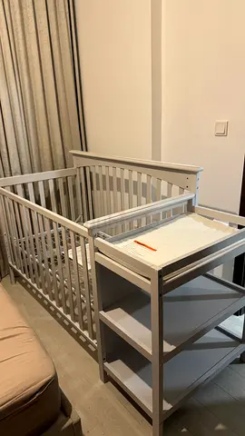 Gray baby crib with matching changing table
