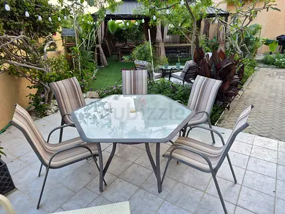 Hexagonal glass-top patio dining table with 5 striped chairs
