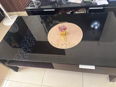 Black glass-top coffee table with lower storage shelf