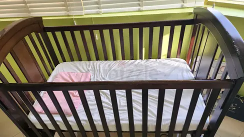 Dark wood convertible baby crib - good condition with the mattress and bed sheets
