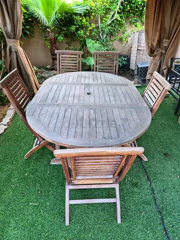Wooden round (or oval when opened)outdoor dining table with 5 chairs.