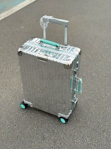 My silver hard-shell rolling carry-on suitcase with teal accents