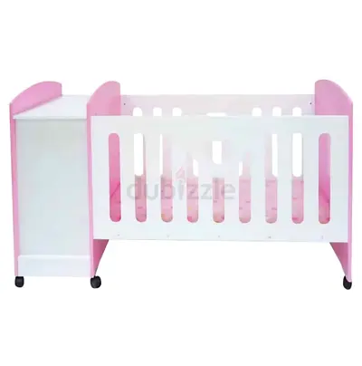 Pink and white baby crib with side storage (on wheels)