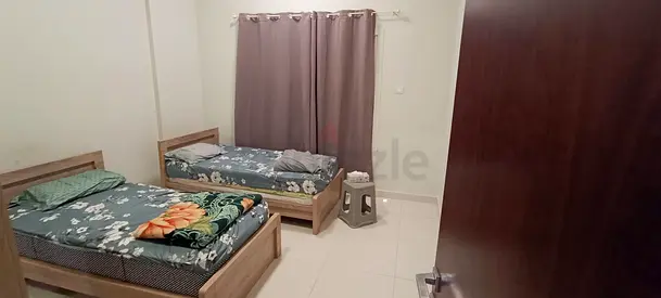 Two single wooden beds with wardrobe