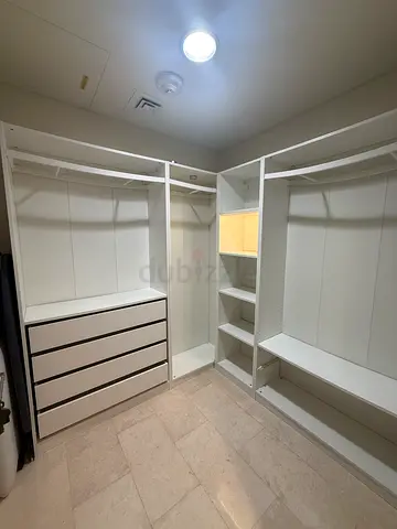 White built-in wardrobe unit with shelves, drawers and hanging rails