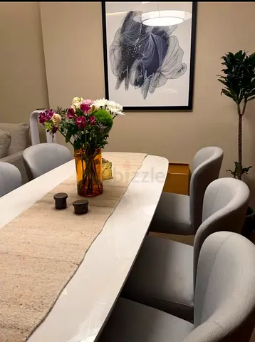 White marble with oak wood base dining table with 6 grey upholstered chairs. Luxury Italian brand