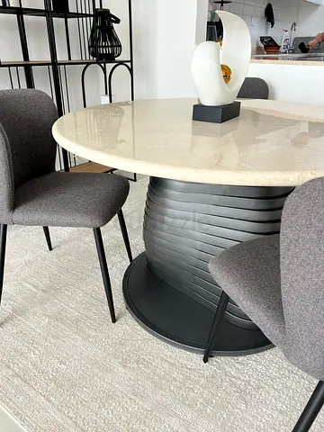 Round marble-top dining table with 4 grey upholstered chairs