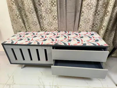 Gray storage bench with cushioned top and 2 drawers