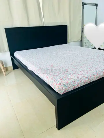 Black wooden bed frame with headboard — minimal design