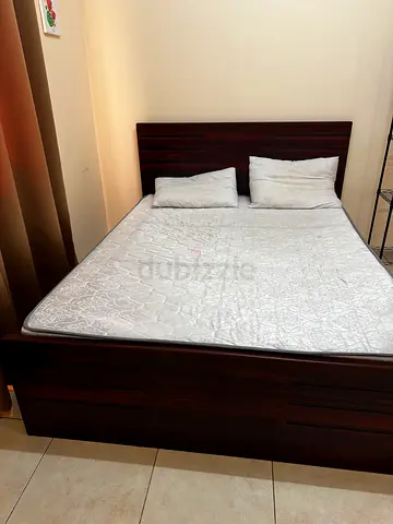 Solid dark wood bed frame with mattress and headboard