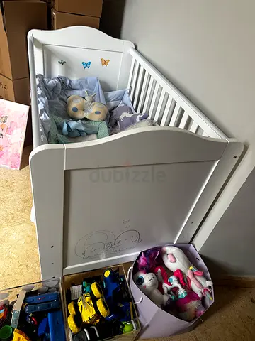 White baby crib with mattress and bedding
