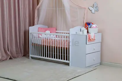 Baby crib with attached dresser and mattress