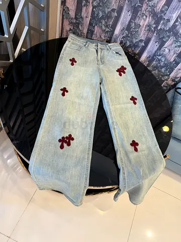 Light-wash denim jeans with burgundy floral patches